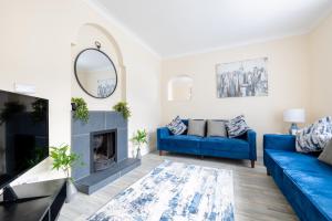 a living room with a blue couch and a fireplace at Varden House in Derry Londonderry