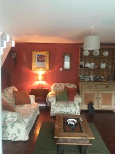 a living room with two couches and a table at Wye Valley near Tintern Abbey Charming cottage within farmhouse Rocklea Farm,Broadstone, Trellech Monmouthshire in Monmouth