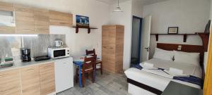 een kleine kamer met een bed en een kleine keuken bij Oleander's Garden Traditional Cretan Cottage in Ferma