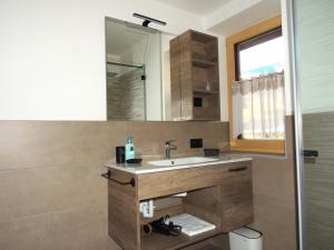 La salle de bains est pourvue d'un lavabo et d'un miroir. dans l'établissement Prà Lisandro, à Cavalese