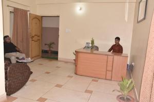 two men sitting at a desk in a room at Atithi Ashray in Patna