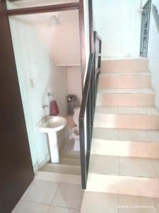 a bathroom with a sink and a staircase with a toilet at Hermoso de´partamento, Un lugar para descansar in Ocotlán