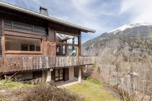 una casa de madera en una colina con una montaña en Chalet Kieppi - View off Mont-Blanc range, en Les Houches