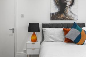 a bedroom with a bed with a lamp on a night stand at Stunning 1 & 2 bedroom Apartments Central London ZONE 1 in London