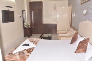 a hotel room with a bed and a tv at Atithi Ashray in Patna