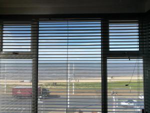 a window with the blinds open in a building with a view of a field at South Beach Kings Promenade Hotel in Blackpool