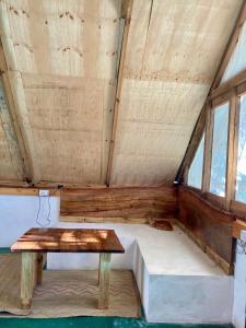ein Bett und einen Tisch in einem Zimmer mit Fenstern in der Unterkunft Pongwe Eco Lodge and kitten paradise. in Mdudu Mdogo