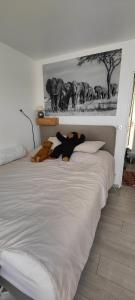 a bed with two stuffed animals laying on it at appartement avec grande terrasse in Le Blanc-Mesnil