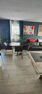 uma sala de estar com uma mesa e cadeiras e um sofá em appartement avec grande terrasse em Le Blanc-Mesnil