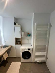 een wasmachine en droger in een kleine keuken bij Gemütliches Businessapartment in Baden-Baden