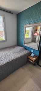 um quarto com uma cama e um espelho na parede em appartement avec grande terrasse em Le Blanc-Mesnil