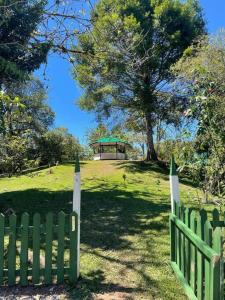 een groen hek met een tuinhuisje in een veld bij Chalet & Kiosko dónde Piedra in San Isidro
