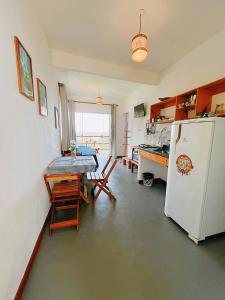 a kitchen with a table and a white refrigerator at Vila Boa Vista Itacaré in Itacaré