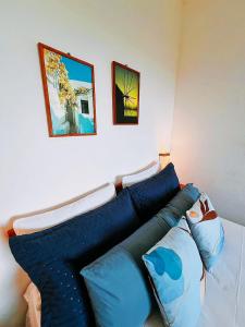 ein Wohnzimmer mit einem Sofa und blauen Kissen in der Unterkunft Vila Boa Vista Itacaré in Itacaré