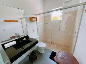 a bathroom with a shower and a toilet and a sink at Vila Boa Vista Itacaré in Itacaré
