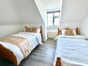 two twin beds in a bedroom with a window at Railway Lodge in Camp