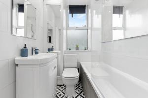 a white bathroom with a toilet and a sink and a tub at Stunning 1 & 2 bedroom Apartments Central London ZONE 1 in London