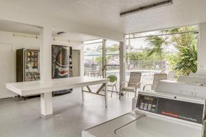 ein Wohnzimmer mit einem Tisch und eine Küche mit einem Balkon in der Unterkunft Hilo Apartment with Lanai - 2 Mi to Beaches! in Hilo