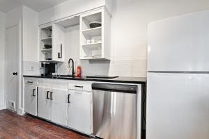 a kitchen with white cabinets and a refrigerator at CityPlace bnb Aparthotel in Dallas