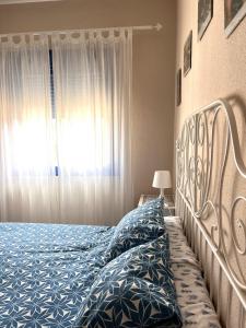 a bedroom with a bed with blue sheets and a window at Apartamento Vista Azul in Costa Ballena