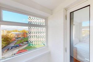 a room with a window with a view of a building at Modern 2BD flat in Bethnal Green- 10 min to tube in London