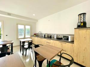uma cozinha com mesas e cadeiras e um micro-ondas em Country & Beach Suites em Cardedu