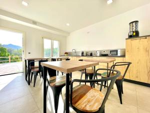 uma cozinha com mesas e cadeiras de madeira num quarto em Country & Beach Suites em Cardedu