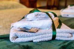 a pile of towels sitting on top of a bed at La Dimora nell'Anfiteatro Superior room and apartment Lift Air conditioning in Lucca