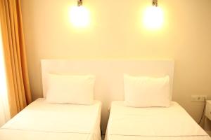 two beds with white sheets and pillows in a room at Eagle Residence Taksim in Istanbul
