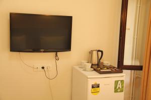 a flat screen tv hanging on a wall above a refrigerator at Eagle Residence Taksim in Istanbul