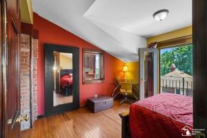 1 dormitorio con pared roja, cama y ventana en Part of Mini-Mansion, private, 3 story Lake Erie views en Luna Pier