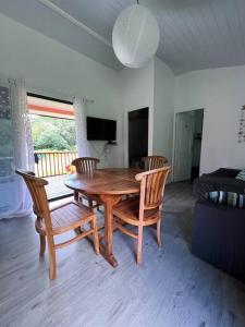 einen Holztisch und Stühle im Wohnzimmer in der Unterkunft Casa Corsa à Moorea in Moorea