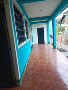Zimmer mit blauen Wänden und roten Fliesenböden in der Unterkunft Casa Xuan in San Juan La Laguna