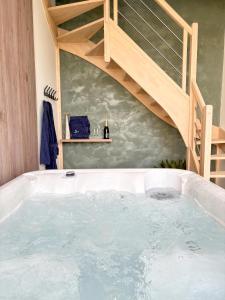 un jacuzzi en un baño con una escalera en L'Escapade Nature et SPA, 10 mn du ZooParc de Beauval, en Saint-Romain-sur-Cher