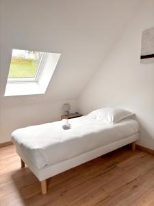 a white bed in a white room with a window at L'Escapade Nature et SPA, 10 mn du ZooParc de Beauval in Saint-Romain-sur-Cher