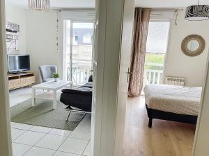1 dormitorio con 1 cama y sala de estar en CABOURG - 2 PIÈCES avec Balcon et parking- Hyper Centre et Plage, en Cabourg