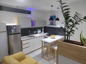 uma cozinha com um lavatório e uma mesa e uma cozinha com um frigorífico em Yaque Suite em El Yaque