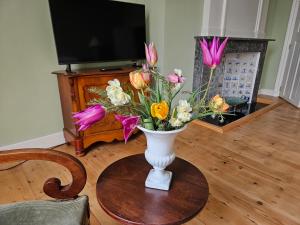 um vaso cheio de flores sentado numa mesa em B&B Monumentaal Logeren em Zierikzee