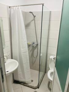 La salle de bains est pourvue d'une douche, de toilettes et d'un lavabo. dans l'établissement Vitamin Sea, à Saranda