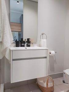 ein weißes Bad mit einem Waschbecken und einem WC in der Unterkunft Executive Apartment at Ellipse Waterfall in Midrand