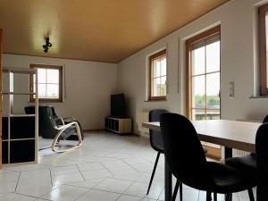 a living room with a dining room table and chairs at Ferienapartments Eifel Stay in Lissendorf