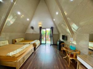 Habitación con 2 camas, mesa y sillas en Homestay Tuyết Anh, en Tri Tôn