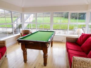 a living room with a pool table and a couch at Gunn's Cottage in Enniskillen