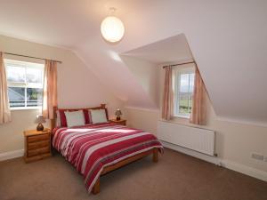 1 dormitorio con 1 cama y 2 ventanas en Gunn's Cottage, en Killyhevlin