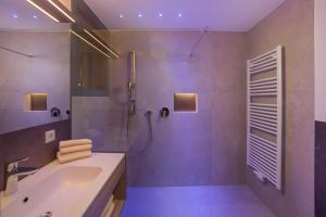ein Bad mit einer Badewanne, einer Dusche und einem Waschbecken in der Unterkunft Residence Alpenrose in St. Johann im Ahrntal
