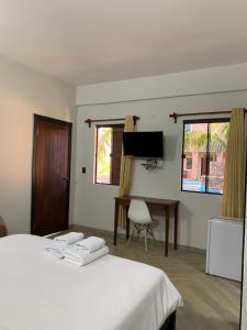 a bedroom with a bed and a desk and a television at Hotel Il Castello in Villa Concepción