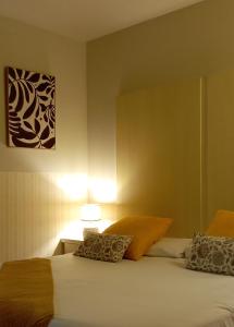 - une chambre avec deux lits et une lampe sur une table dans l'établissement Petit Hotel de Riu, à Riu de Cerdanya