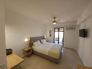 a bedroom with a bed and a ceiling fan at Boomerang Sea View Accommodation and Studios in Plános