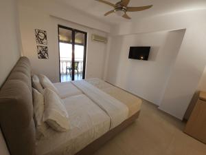 a bedroom with a bed with a ceiling fan at Boomerang Sea View Accommodation and Studios in Plános