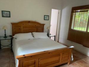 a bedroom with a large bed with a wooden headboard at LA QUINTA in Capilla del Señor